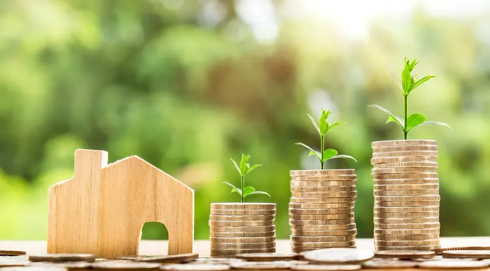 A house shown under protective hands, a picture of mortgage insurance that protects the lender
