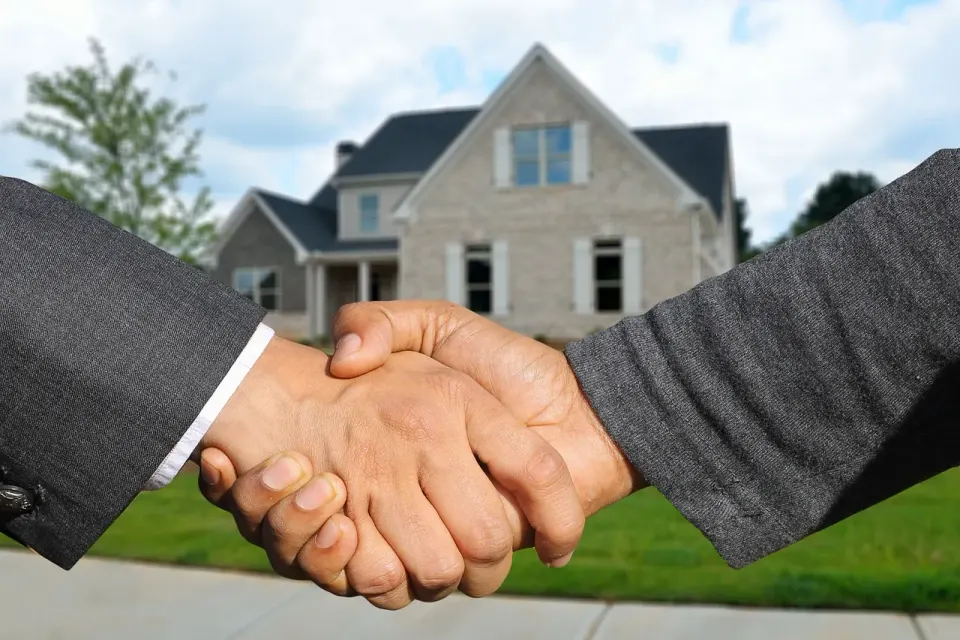 A real estate agent handing over a contract, part of making and negotiating an offer